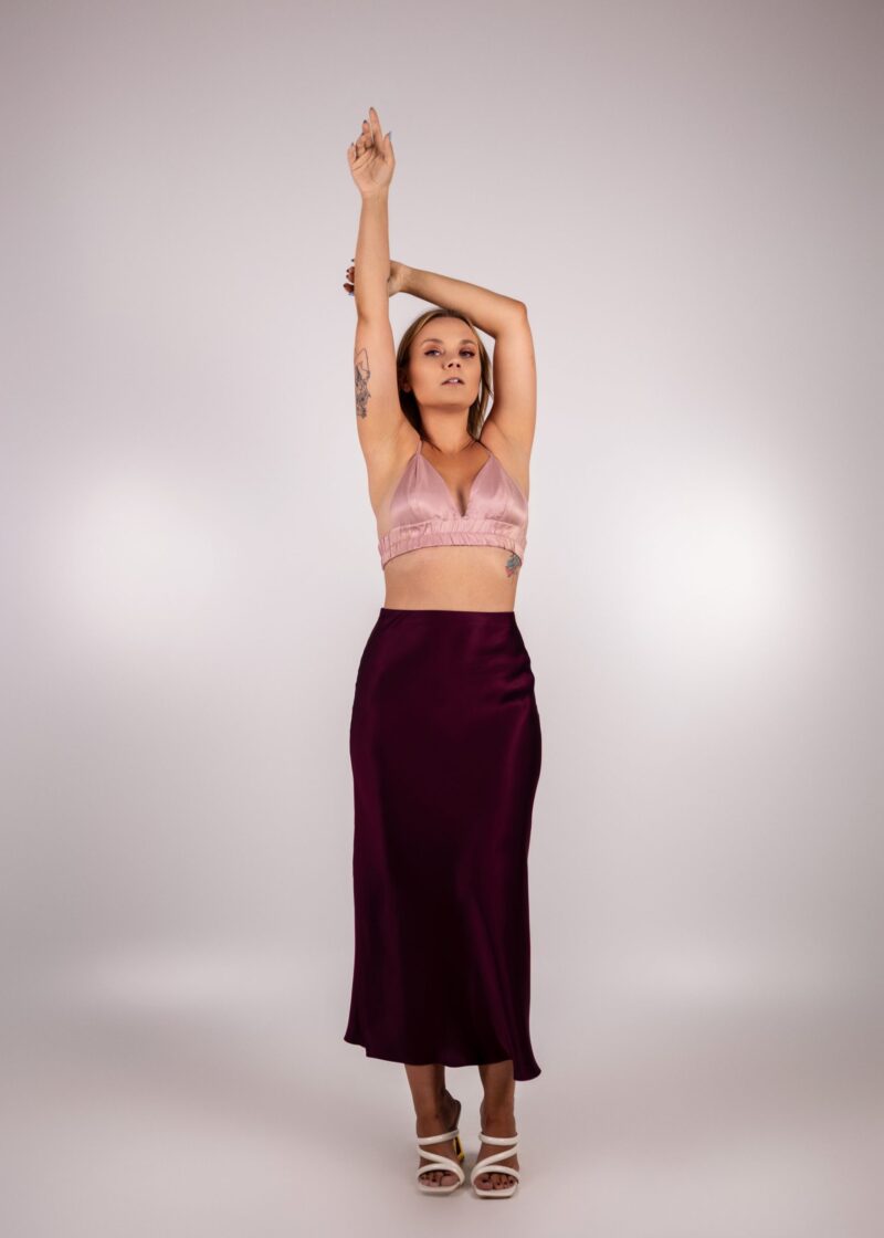 Góra piżamki z różowej wiskozowej satyny w zestawie ze bordową spódnicą, noszona z sandałami na fantazyjnym obcasie